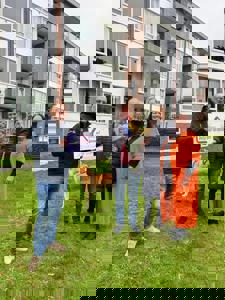 Armand krijgt de prijs uit handen van Rob van Beek. De buurvrouwen die hem nomineerden staan naast hem.